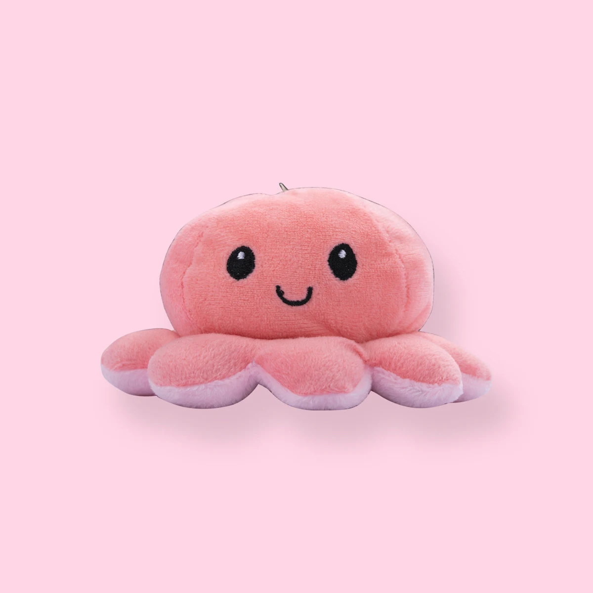 Small pink plush octopus with a smiling face